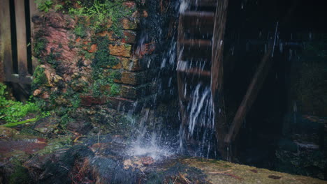 Rustikale-Wassermühle-In-Zeitlupe,-Nahaufnahme-Von-Wasser,-Das-Auf-Die-Felsen-Trifft