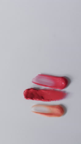 vertical video of lipstick smudges with copy space on white background