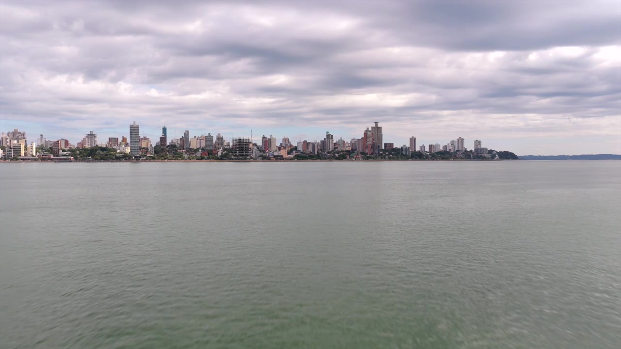 El horizonte de la ciudad de Posadas, Argentina, se extiende a lo largo del río bajo un manto de nubes cubiertas. Perfecto para estudios urbanos o contenido de viajes