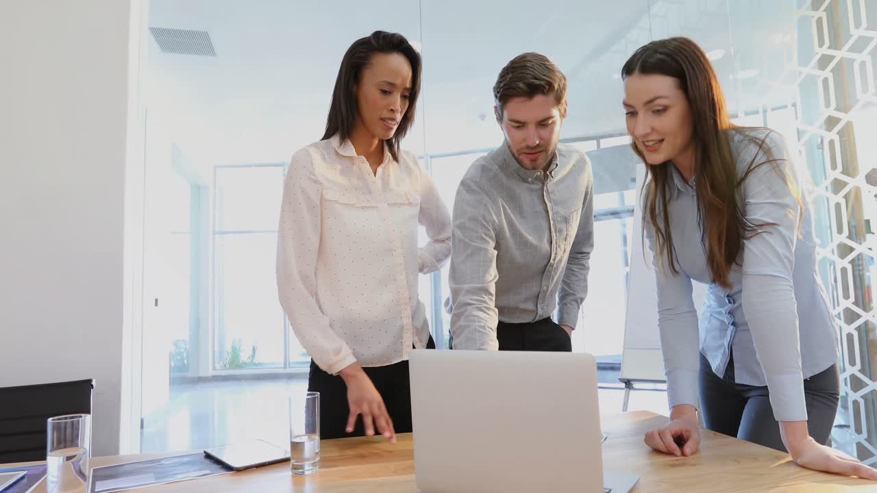 colegas de negocios discutiendo sobre una computadora portátil 4k