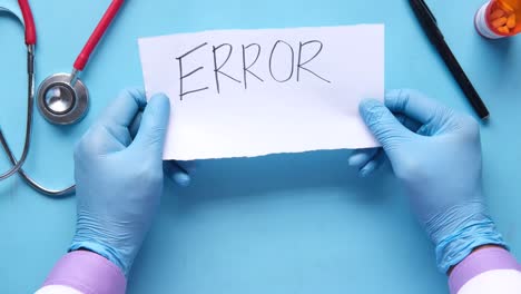 doctor holding a note with the word error written on it.