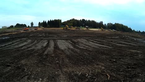 excavators are working with buckets to clear mud sludge and debris from the bottom of the drained river