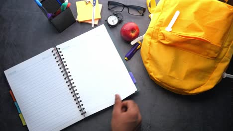 el escritorio del estudiante con el cuaderno abierto y la mochila
