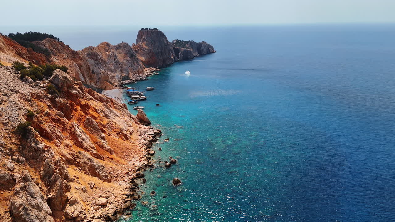 Cliffs and clear sea waters. Rocky cliffs meet vibrant blue waters under a clear sky, showcasing a serene coastal landscape filled with nature
