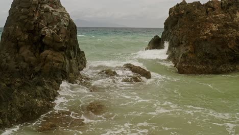 Ocean-Rocks-with-Slow-Motion-Waves-Splashing-in-Turquoise-Waters-of-Banbanon-Beach-in-Surigao-Del-Norte,-Philippines