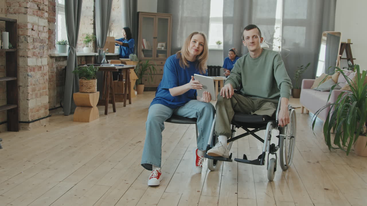 Volunteer Helping Man with Disability to Set Up Internet on Tablet
