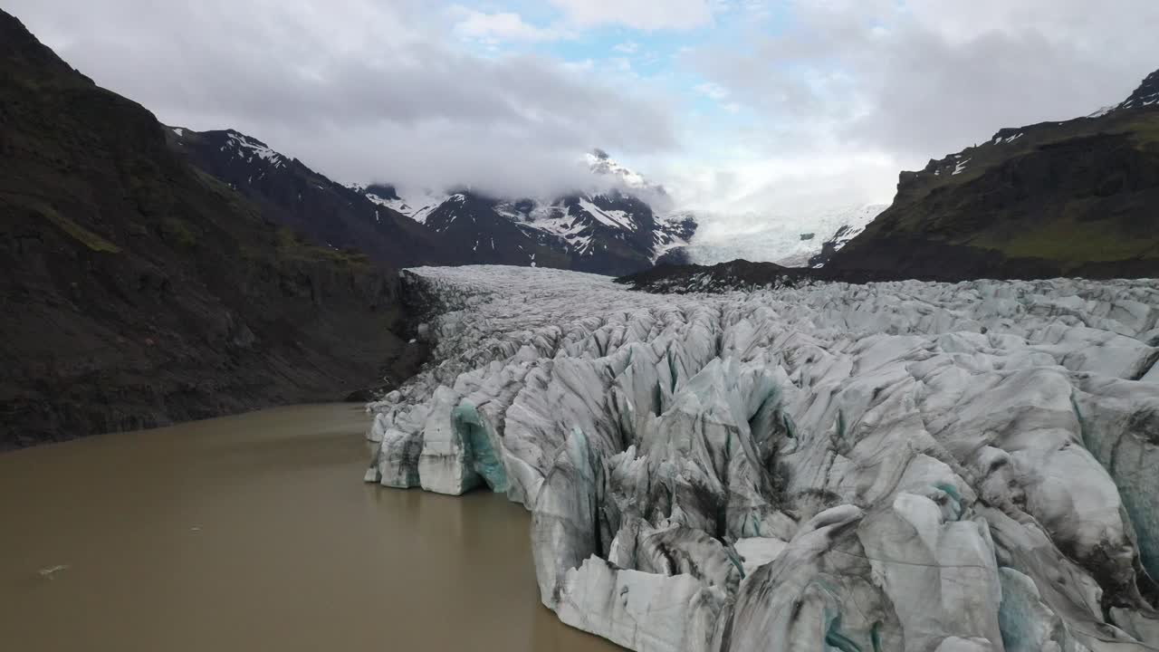 물이 있는 아이슬란드 빙하가 앞으로 나아가는 무인 항공기 비디오와 함께 닫힙니다.