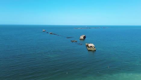 drone footage of arromanches in normandy showing the remains of the world war ii artificial harbour,