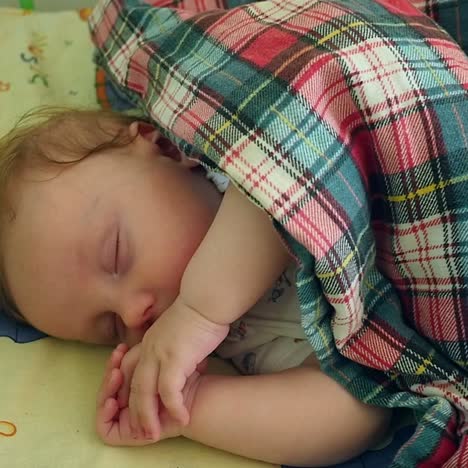 sleeping baby covered in the crib