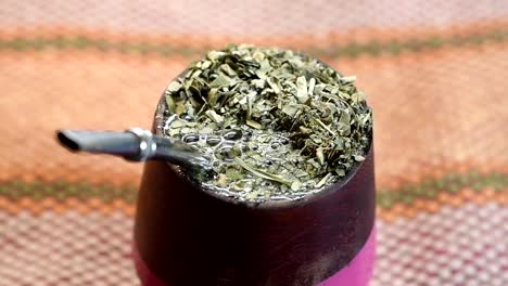vertiendo agua en un "mate" de madera