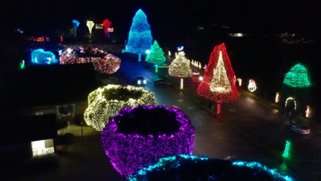 Drone-night-shot-of-trees-lit-in-thousands-of-colorful-Christmas-lights