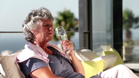 mature woman enjoying glass of wine on balcony