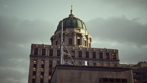 a close-up shot of a tall building with a dome on top, against a cloudy sky.