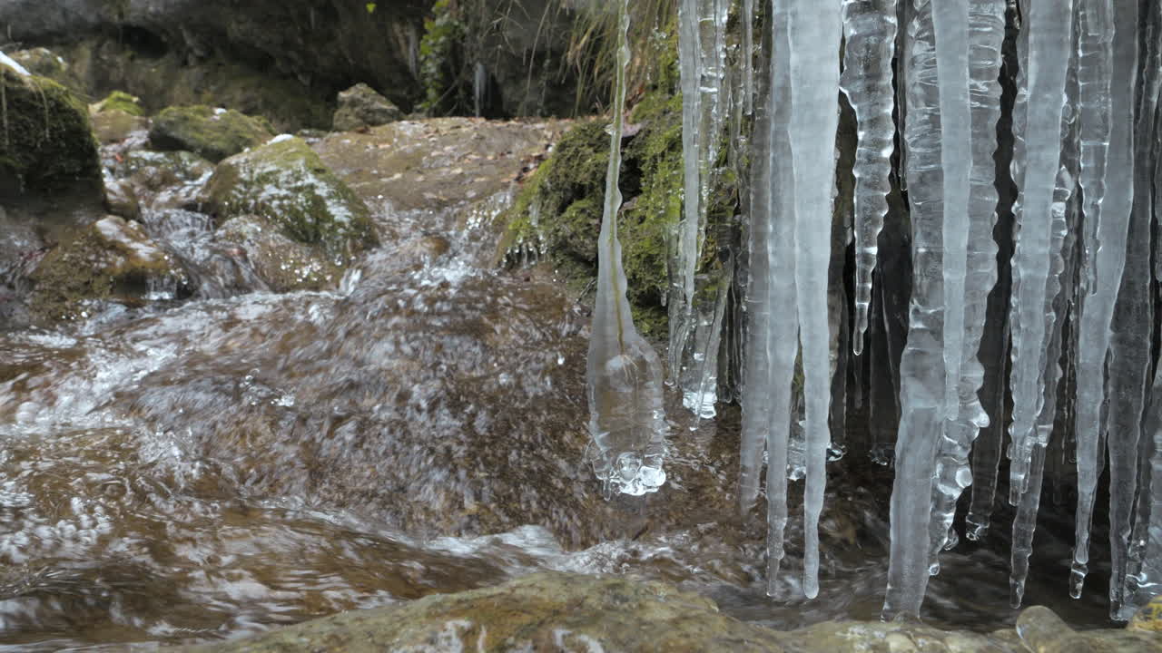 corriente de agua clara que fluye de los alpes con hielos colgantes en la naturaleza, disparo de cerca