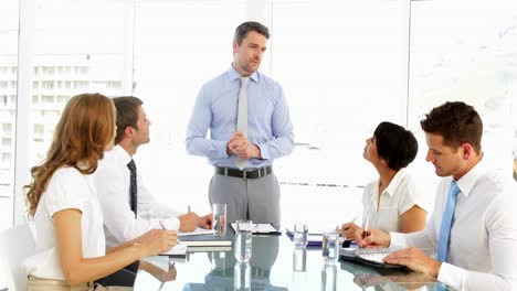 hombre de negocios de pie y hablando durante la reunión