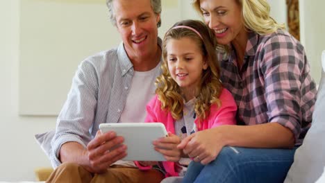 smiling family using digital tablet together in living room 4k