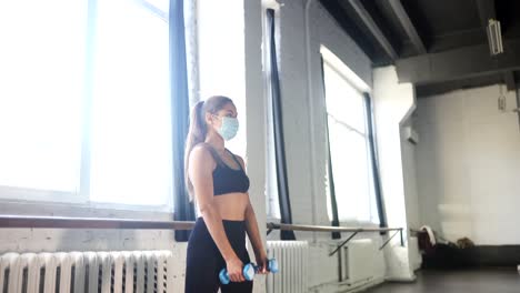 mujer trabajando en un gimnasio con una máscara durante la covid-19