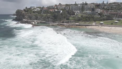 Landschaft-Aus-Weißen-Plätschernden-Wellen-Am-Bronte-Beach-Mit-Bronte-poolbädern-In-östlichen-Vororten,-Sydney,-New-South-Wales,-Australien