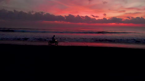 silhouette of a motorcyclist riding on the beach at sunset