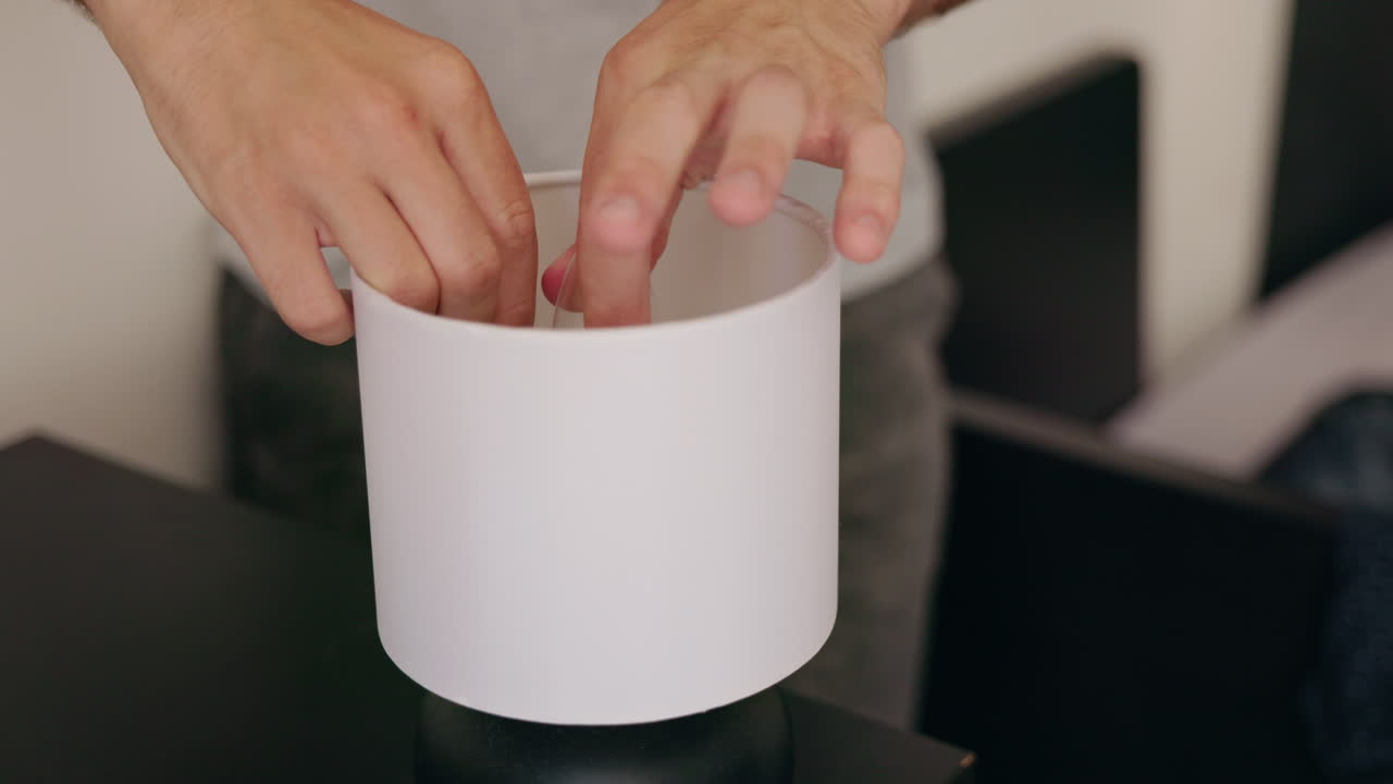 Close-up of hands assembling a table lamp