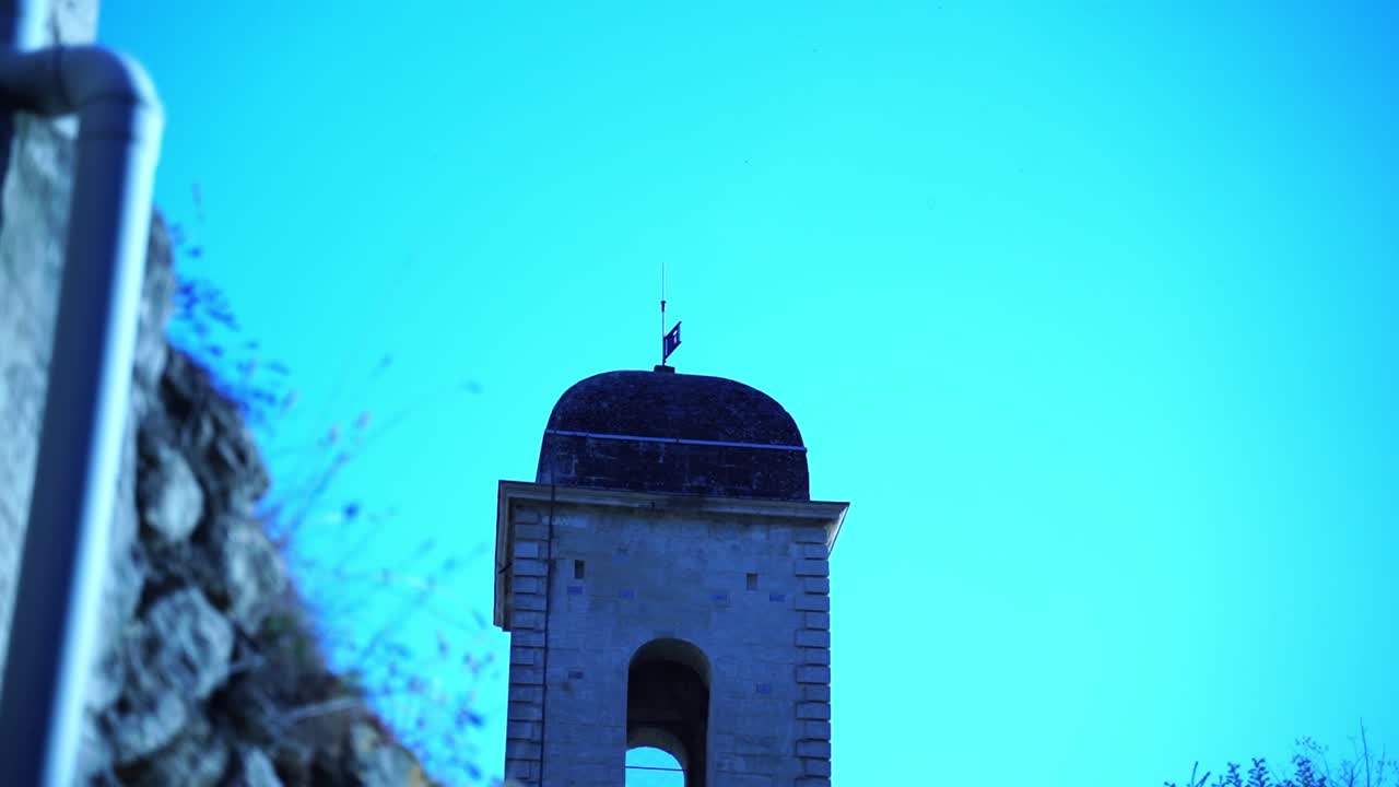 torre de una iglesia en el sur de francia entre las paredes de piedra de un pequeño pueblo francés