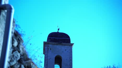 Torre-De-La-Iglesia-En-El-Sur-De-Francia-Entre-Muros-De-Piedra-De-Un-Pequeño-Pueblo-Francés