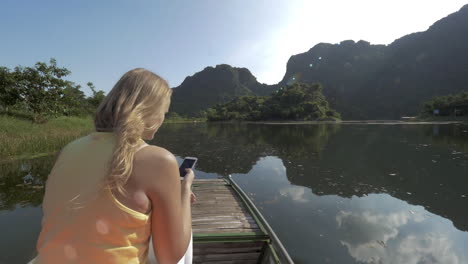 mujer viajera con móvil tomando fotos durante trang un viaje en barco a vietnam