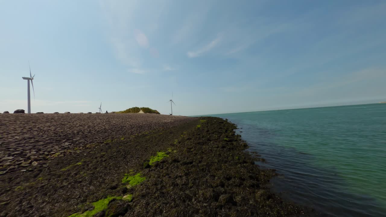 밝은 푸른 하늘 아래 긴 바다 해안과 청록색 바다의 낮은 각도 샷
