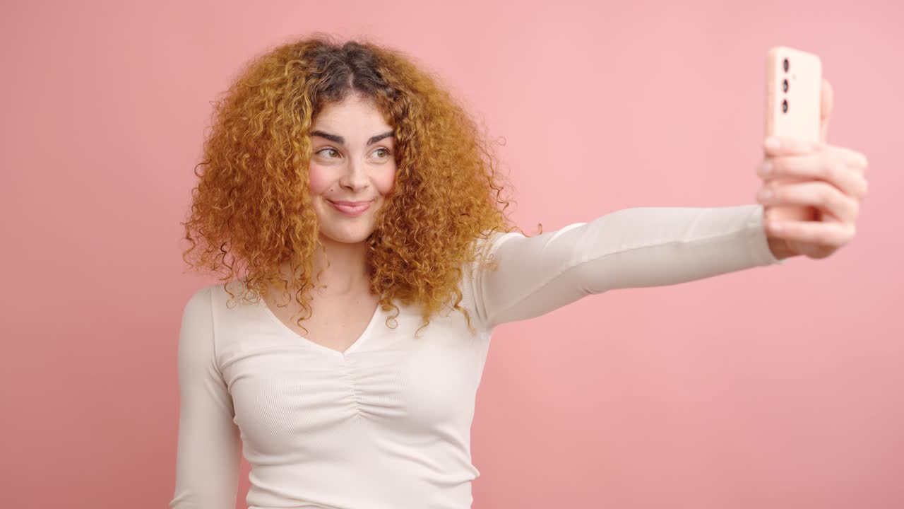 Influencer posing for social media content on pink background
