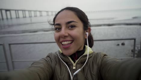 funny hindu woman posing for selfie at blurred seascape background