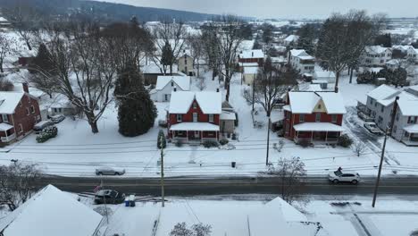 snow blankets a quiet residential neighborhood, featuring classic homes captured by a drone in the usa