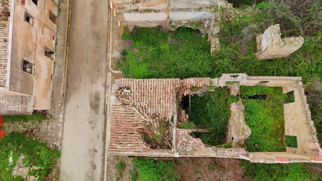 Vista de dron de un edificio abandonado y la naturaleza reclamándolo, con un ambiente tranquilo