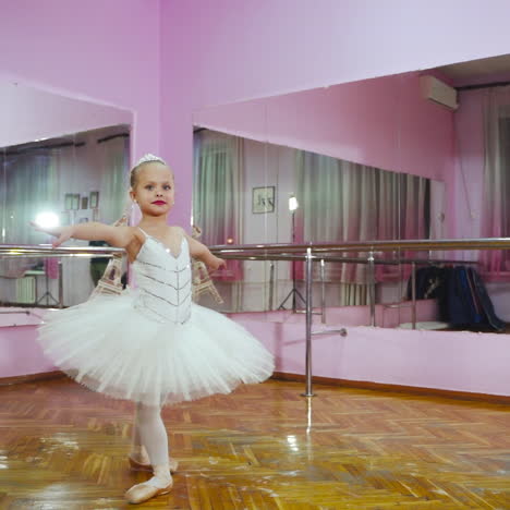 ballerina dansen in de studio voor de spiegel. in de balletzaal. een kleine danseres. slow motion.