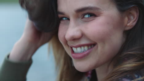 close-up-portrait-happy-young-woman-laughing-having-fun-feeling-excited-playfully-running-hand-through-hair-with-wind-blowing-outdoors-by-lake-4k