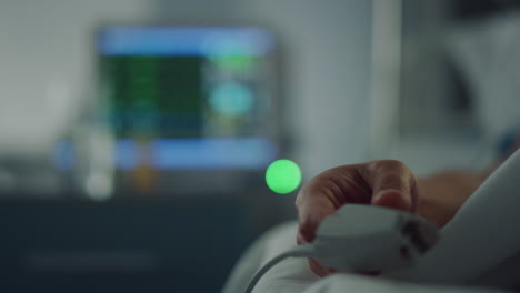 oximetro de pulso en el dedo en el hospital de cerca. monitor de ecg muestra el ritmo cardíaco.
