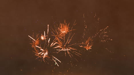 animación de chispas de luz sobre fuegos artificiales que explotan contra un fondo marrón con espacio de copia