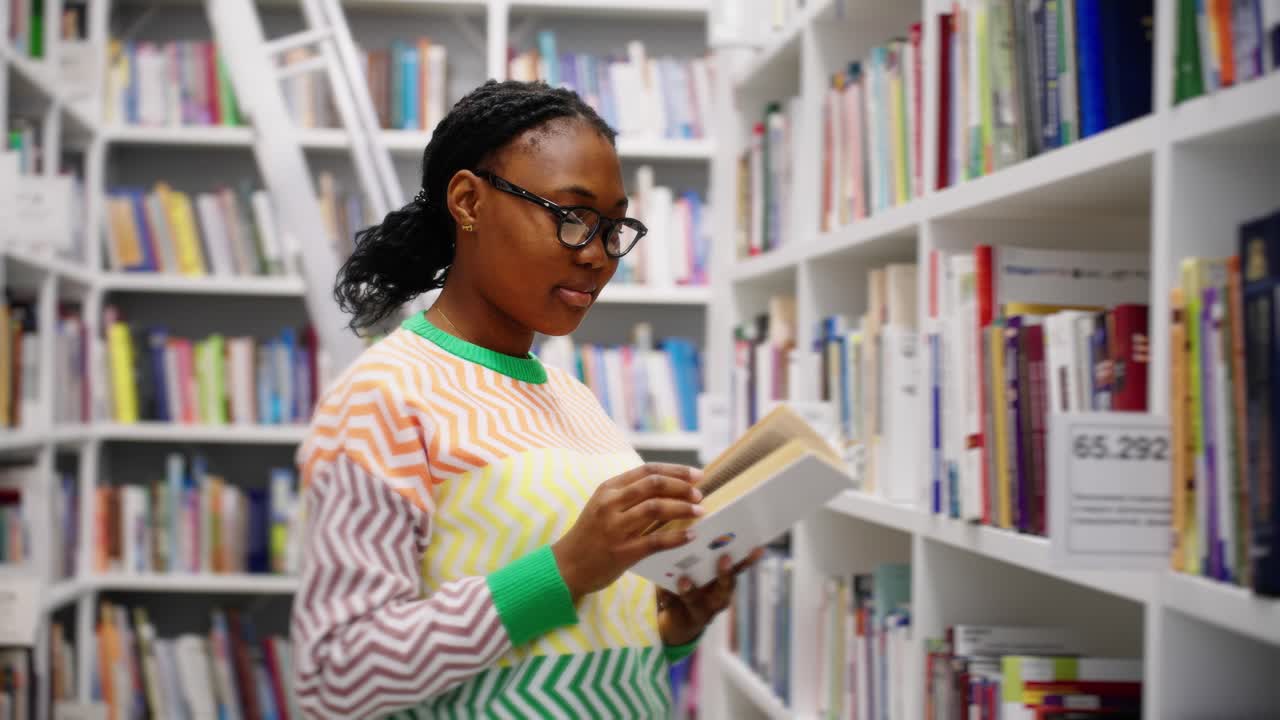 Young Black Woman Reading a Book in a Library