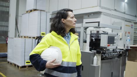 confident female printing technician walking at factory