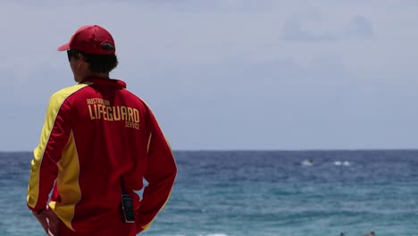 lifeguard in red uniform monitoring the ocean