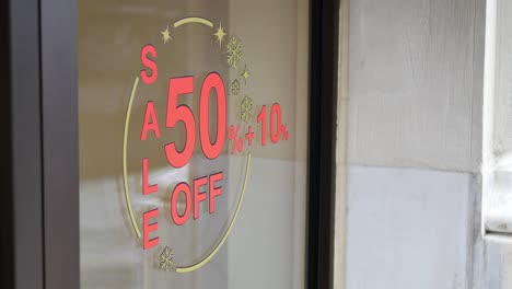 store window with 50% off sale sign