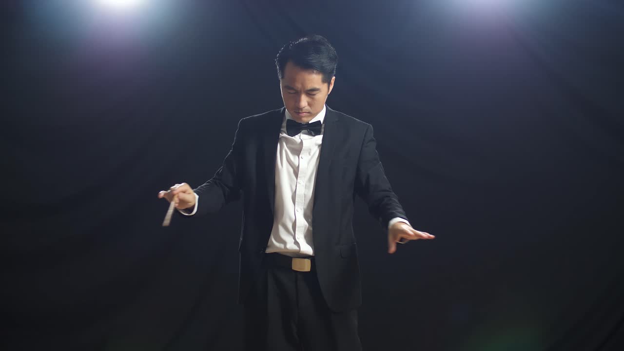 흑인 스튜디오에서 눈을 감고 몸짓을 하는 아시아인 지휘자