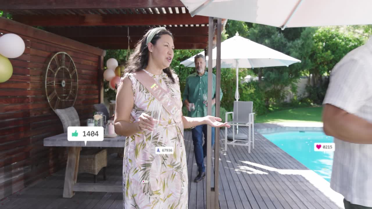 Birthday honoree raising flute while guests presenting cake on deck activating social media hearts