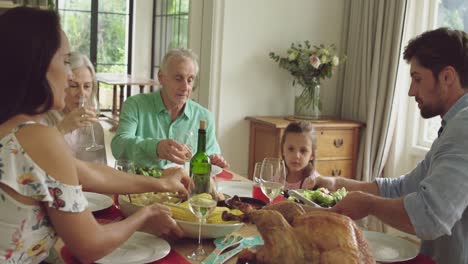 tres generaciones de familia comiendo juntas.