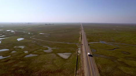 RV,-Recreational-Vehicle,-Bus-travels-down-lonely-roadway-in-California-near-Merced-California,-road-trip