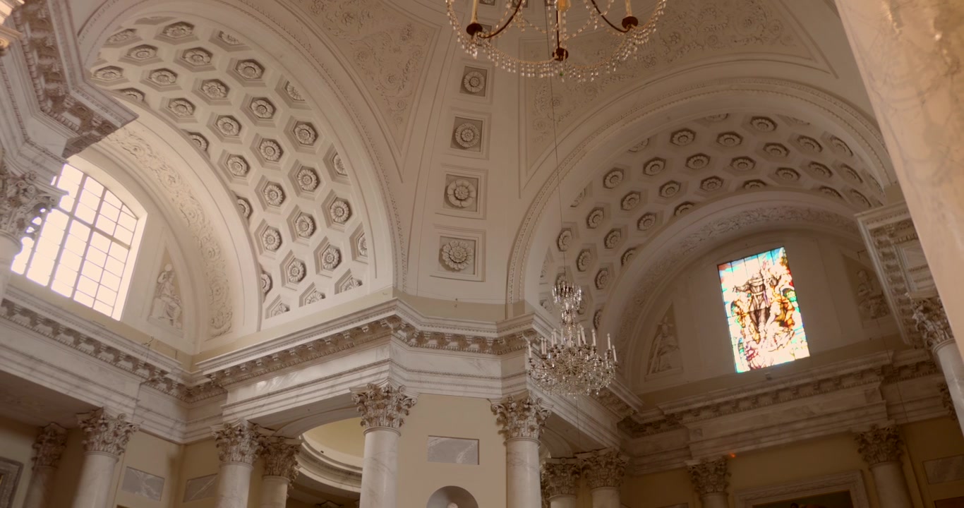 Innenansicht der Basilika San Maurizio in Imperia, Italien, mit großartiger neoklassizistischer Architektur, verzierten Details und einer kassettierten Kuppeldecke. Aufnahme aus der Froschperspektive