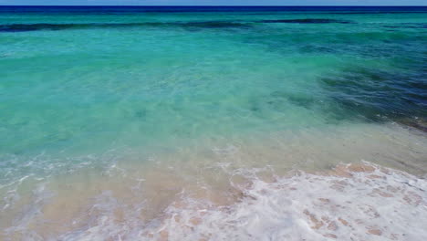 turquoise blue ocean waves crashing on tropical beach on sunny day with no people