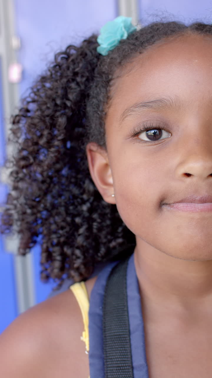 Vertical video: In school, young girl with curly hair smiling