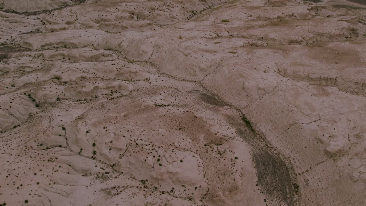 Riprese aeree di terreno arido con un canale di fiume secco e sinuoso e colline di argilla erose. Texture e motivi naturali della terra nella Repubblica dell'Altai, Russia.