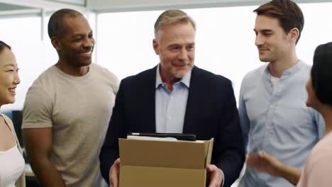 celebrating team success: a group of colleagues shares joyous moments while presenting a gift box, symbolizing appreciation and camaraderie in the workplace