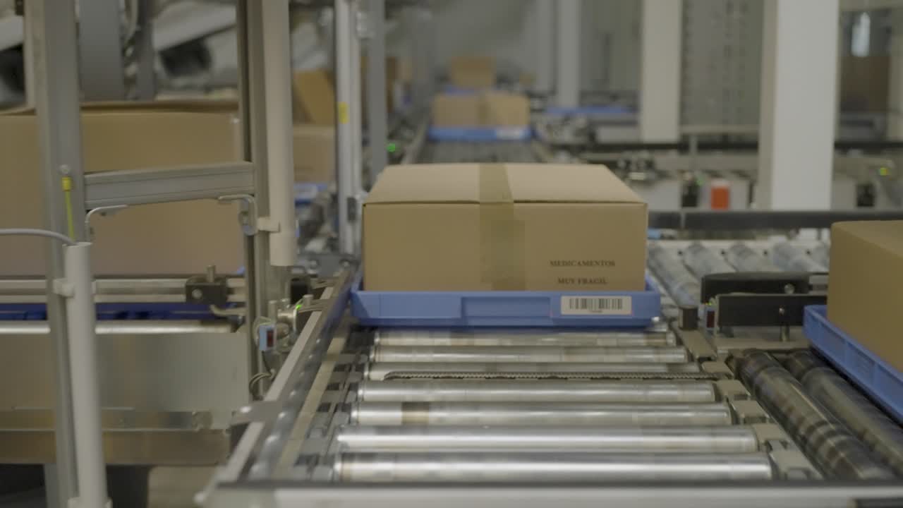 Cardboard box on a conveyor belt moving through an automated warehouse distribution system